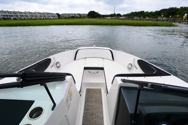 Slide: The Image of 2018 Sea Ray SPX 210 Outboard boat on calm water, with residential buildings in background. - 12
