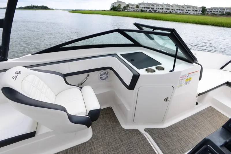 Slide: The Image of 2018 Sea Ray SPX 210 Outboard interior with white seating and dashboard, overlooking serene water. - 14