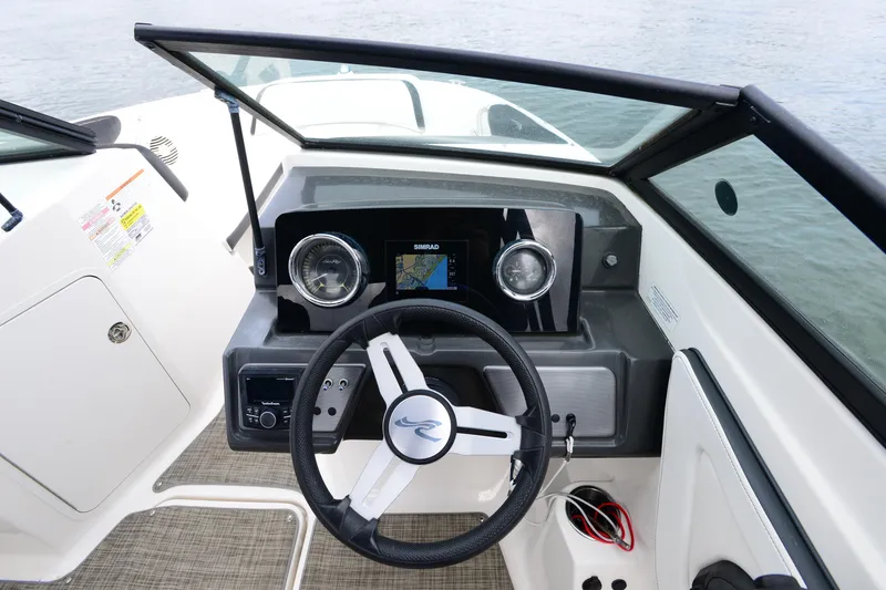 Slide: The Image of 2018 Sea Ray SPX 210 Outboard dashboard with steering wheel and navigation display. - 17