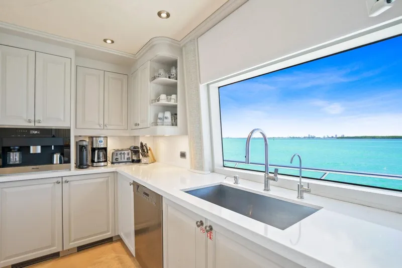 Slide: The Image of Luxurious yacht kitchen with ocean view, featuring modern appliances and sleek white cabinetry. - 13