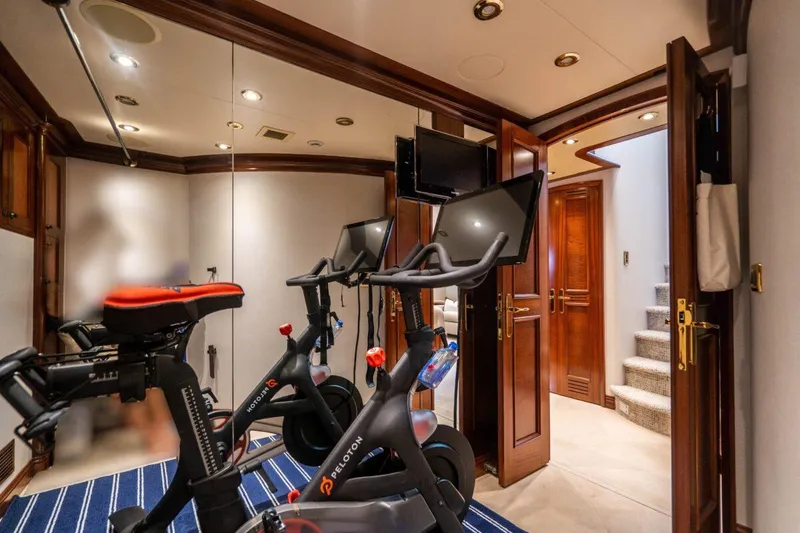 Slide: The Image of Luxury yacht gym with Peloton bikes, mirrored walls, and elegant wood accents, Crescent Raised Pilothouse 2004. - 35