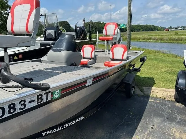 Slide: The Image of 2010 Bass Tracker Pro 16 boat with red and white seats, parked near a lake. - 3