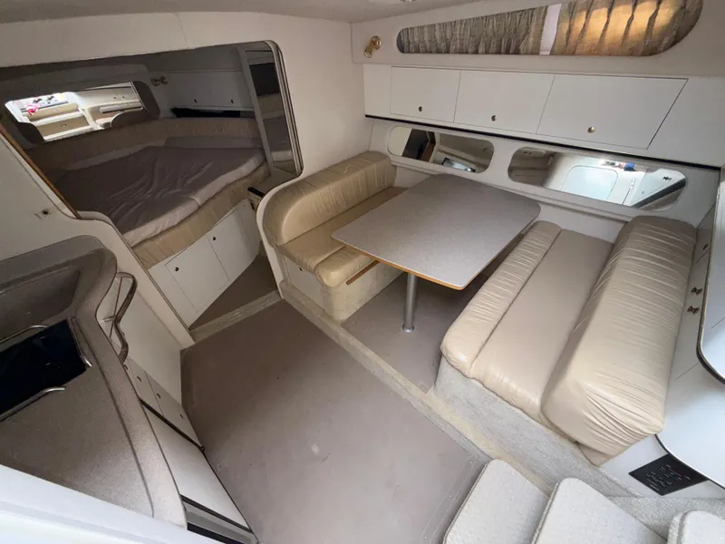 Slide: The Image of Interior of 2001 Sea Ray 340 Amberjack, featuring cozy seating and a compact dining area. - 13