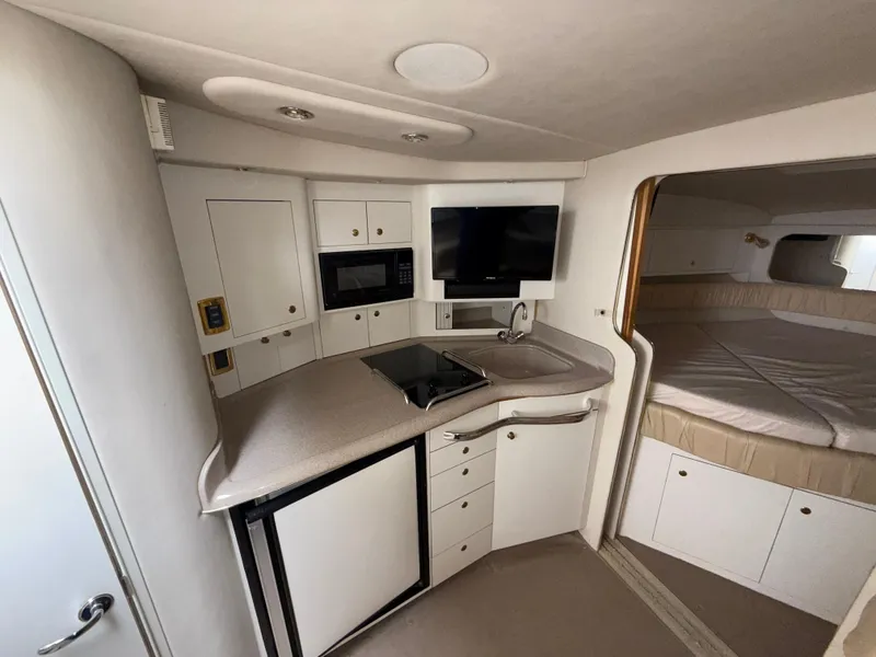 Slide: The Image of Interior of 2001 Sea Ray 340 Amberjack, featuring kitchenette and sleeping area. - 17