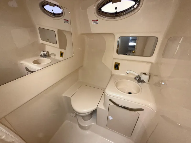 Slide: The Image of 2001 Sea Ray 340 Amberjack bathroom with sink, toilet, and porthole window. - 18