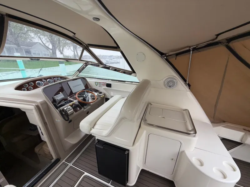 Slide: The Image of 2001 Sea Ray 340 Amberjack cockpit with steering wheel, Garmin display, and seating. - 2