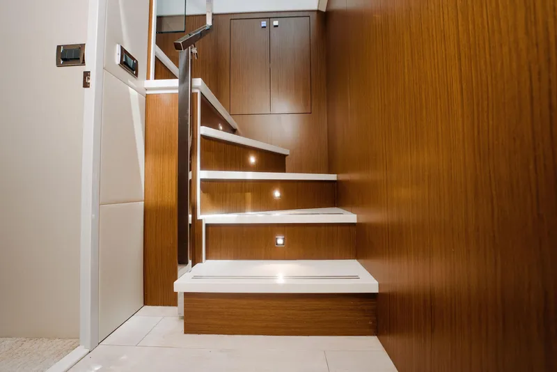 Slide: The Image of Staircase with wooden paneling and modern lighting on a 2017 Hatteras M75 Panacera yacht. - 29