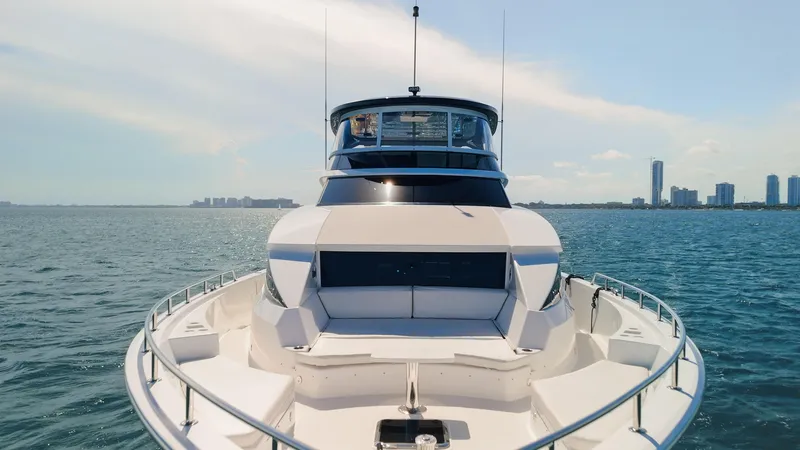 Slide: The Image of 2017 Hatteras M75 Panacera yacht cruising on open water with city skyline in background. - 7