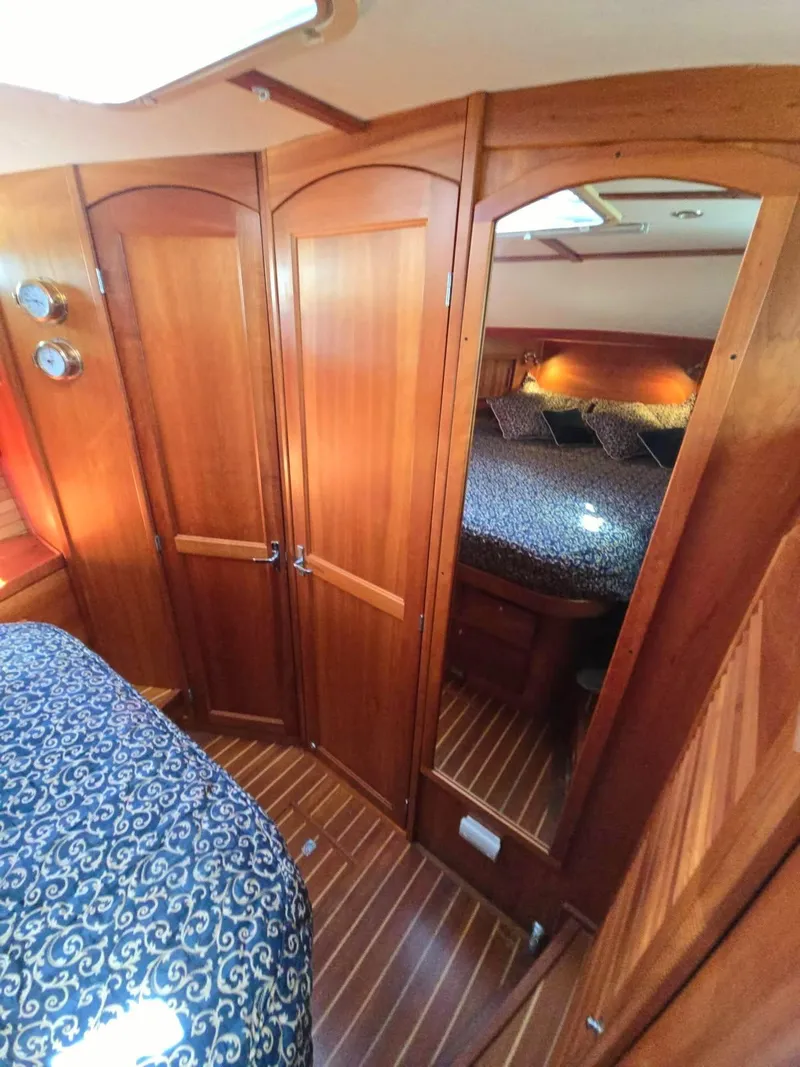 Slide: The Image of Interior of 2004 Sabre 36 Flybridge Fast Trawler with wood paneling and cozy bedding. - 26