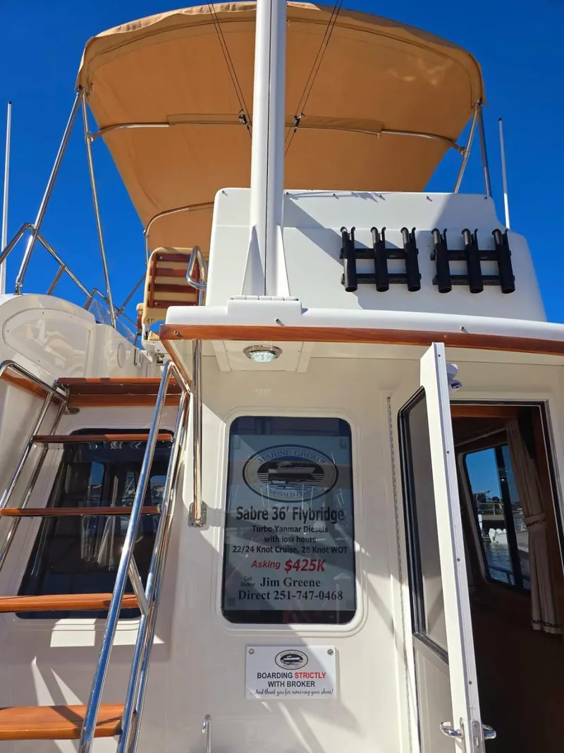 Slide: The Image of 2004 Sabre 36 Flybridge Fast Trawler with tan canopy and wooden accents. - 6