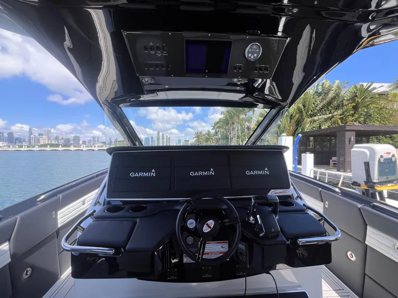 Slide: The Image of 2024 Cigarette 42 Auroris yacht cockpit with Garmin navigation, overlooking waterfront cityscape. - 13