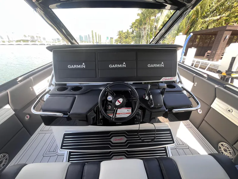 Slide: The Image of 2024 Cigarette 42 Auroris boat cockpit with Garmin navigation displays, sleek design, and waterfront view. - 14