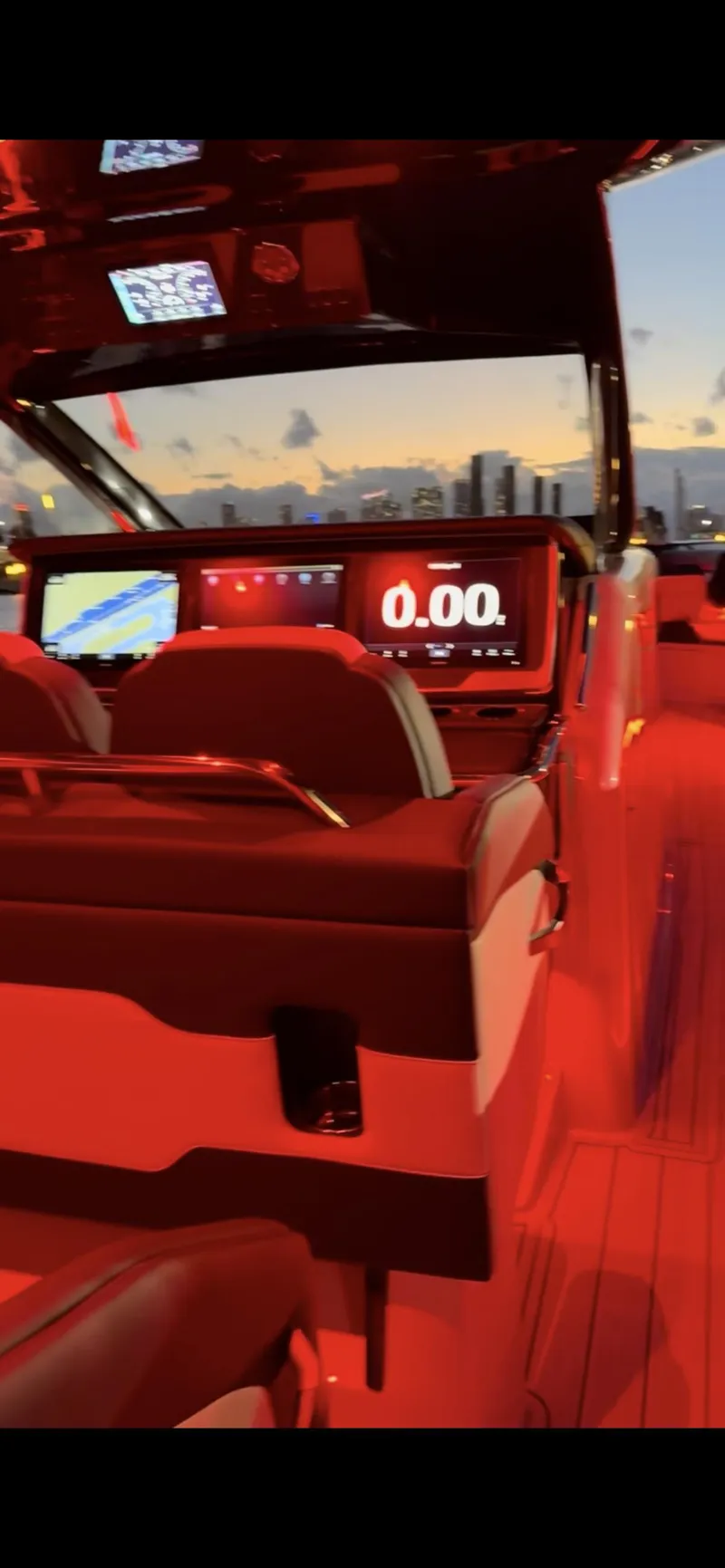 Slide: The Image of 2024 Cigarette 42 Auroris boat interior with illuminated dashboard at sunset. - 18