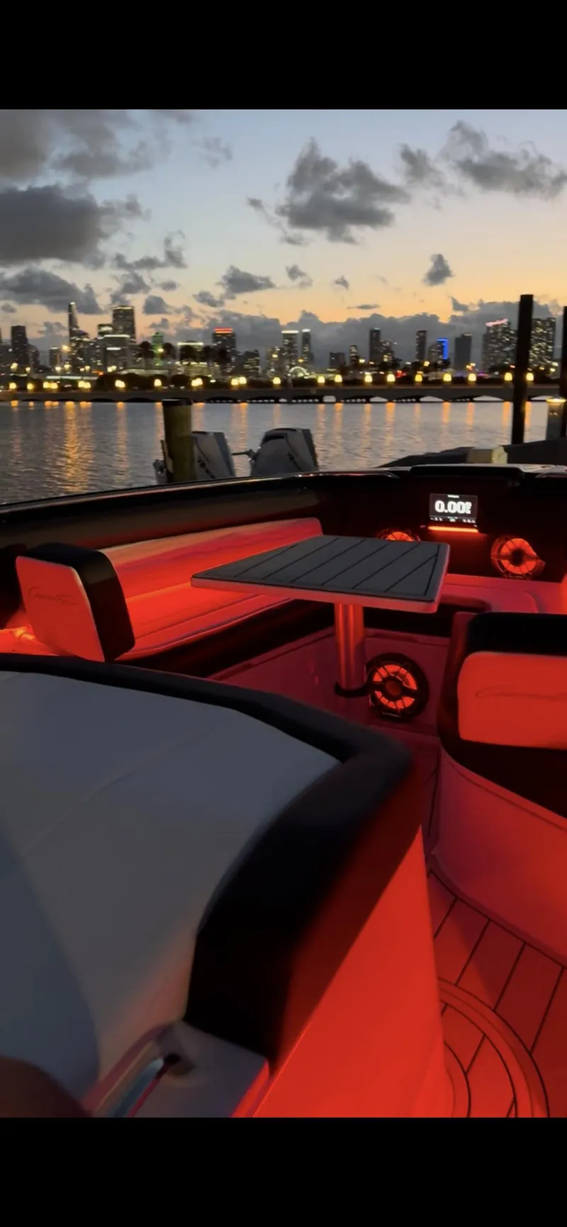 Slide: The Image of 2024 Cigarette 42 Auroris boat interior with red lighting, city skyline at sunset. - 28