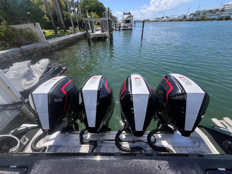 Slide: The Image of 2024 Cigarette 42 Auroris boat with four powerful outboard engines docked by the water. - 3