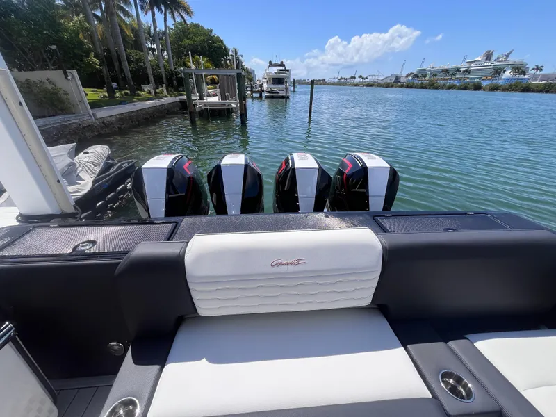 Slide: The Image of 2024 Cigarette 42 Auroris boat with four engines docked by a scenic waterfront. - 4