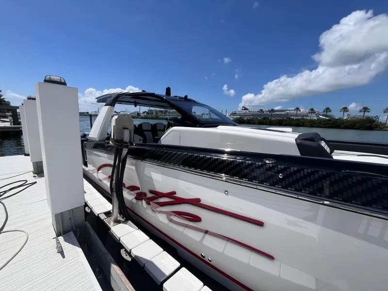 Slide: The Image of 2024 Cigarette 42 Auroris boat docked under a clear blue sky. - 42