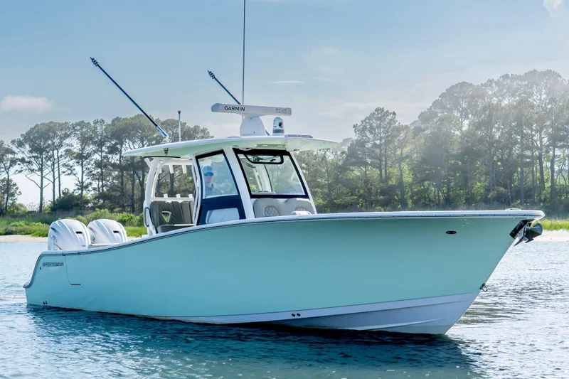 Slide: The Image of 2021 Sportsman Open 322 Center Console boat on calm water, surrounded by trees. - 0