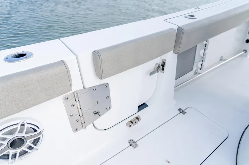 Slide: The Image of 2021 Sportsman Open 322 Center Console boat interior with cushioned seating and speaker. - 16