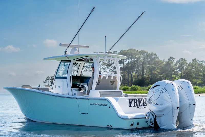 Slide: The Image of 2021 Sportsman Open 322 Center Console boat on calm water, featuring dual engines. - 3