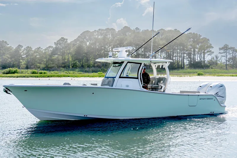 Slide: The Image of 2021 Sportsman Open 322 Center Console boat on calm water, surrounded by trees. - 4