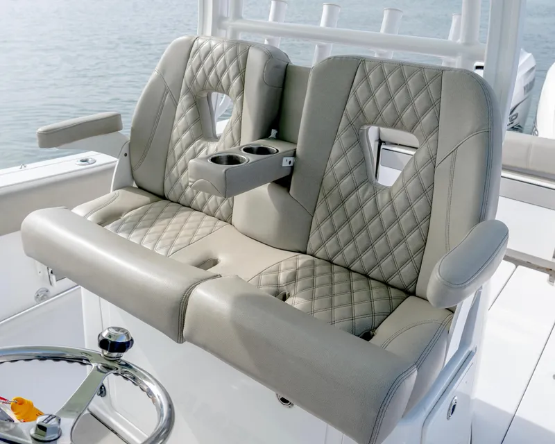 Slide: The Image of 2021 Sportsman Open 322 Center Console boat seats with diamond stitching and cup holders. - 9