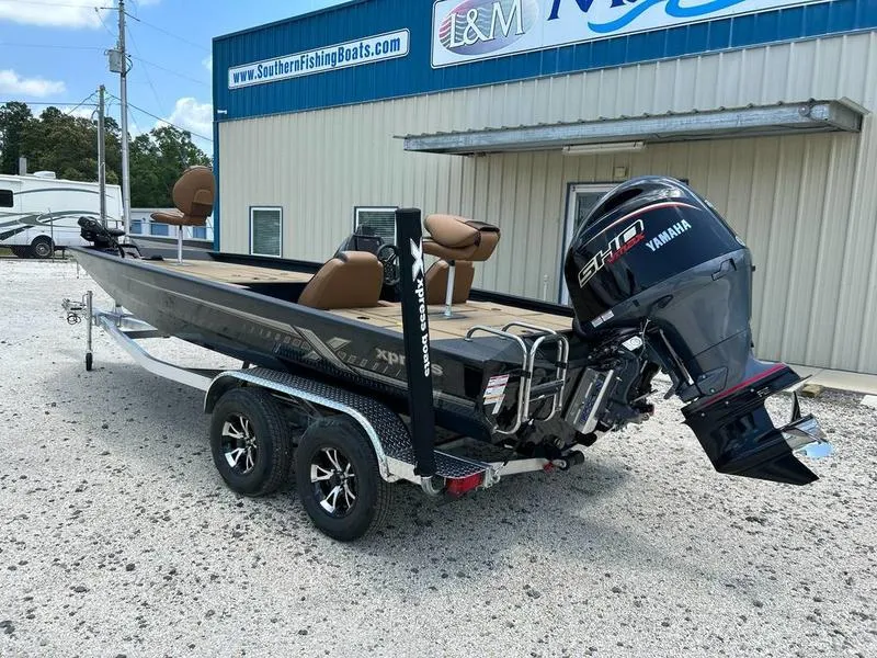 Slide: The Image of 2025 Xpress H20C Crappie boat with Yamaha engine on a trailer outside a dealership. - 1