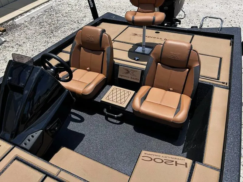 Slide: The Image of 2025 Xpress H20C Crappie boat interior with tan seats and steering console. - 4