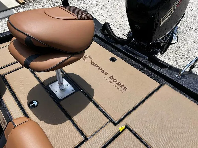 Slide: The Image of 2025 Xpress H20C Crappie boat interior with brown seating and logo on deck. - 5