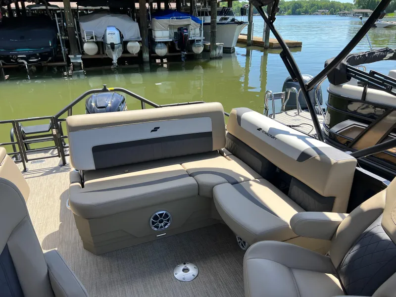 Slide: The Image of 2025 Starcraft SLS 3 Q DH pontoon boat interior with beige seating by a dock. - 16