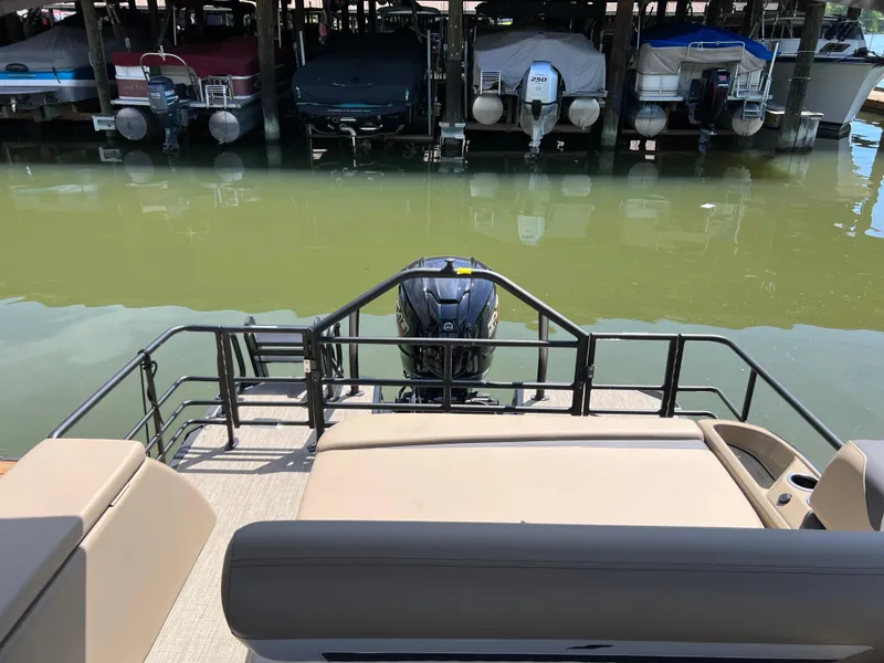 Slide: The Image of 2025 Starcraft SLS 3 Q DH pontoon boat docked, rear view with motor. - 20