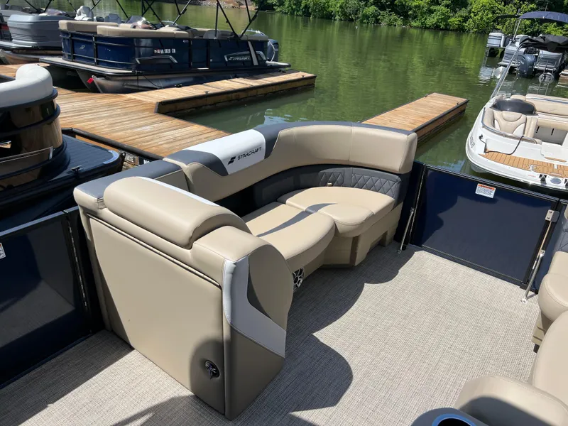 Slide: The Image of 2025 Starcraft SLS 3 Q DH pontoon boat interior with beige seating at a dock. - 6