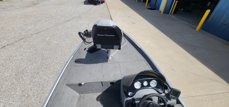 Slide: The Image of 2008 Tracker Pro Team 170 TX boat with console and motor, parked near a garage. - 6