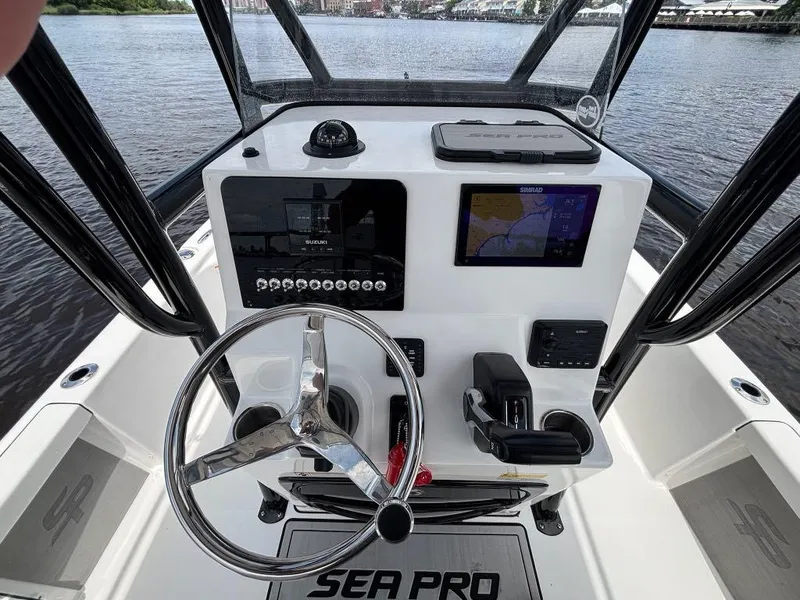 Slide: The Image of 2024 Sea Pro 230 Bay boat dashboard with steering wheel and navigation system. - 11