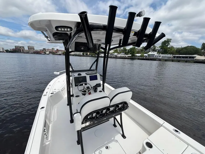 Slide: The Image of 2024 Sea Pro 230 Bay boat with dual seats and rod holders on a calm river. - 14