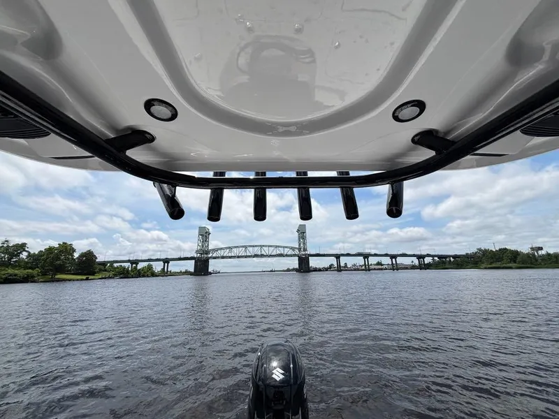 Slide: The Image of 2024 Sea Pro 230 Bay boat on water, bridge in background, under cloudy sky. - 16