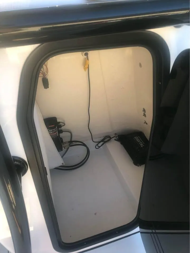 Slide: The Image of 2024 Sea Pro 230 Bay boat storage compartment with wiring and equipment. - 20
