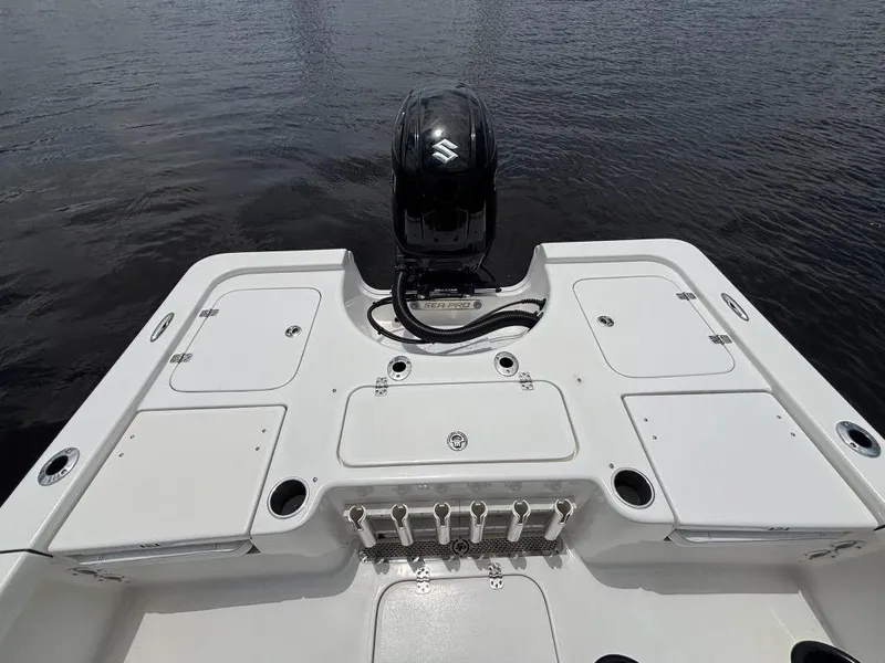 Slide: The Image of 2024 Sea Pro 230 Bay boat deck with Suzuki outboard motor on calm water. - 8