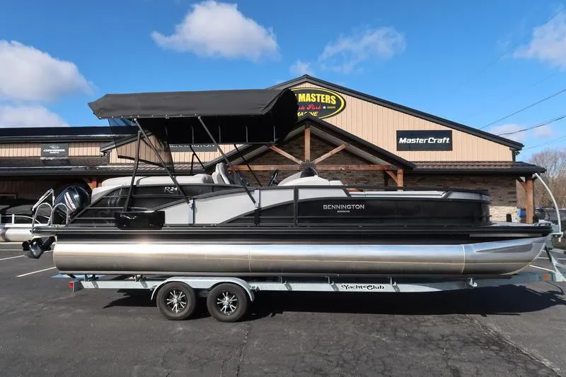 Slide: The Image of 2021 Bennington 24 RTFB pontoon boat on trailer, parked outside dealership. - 1