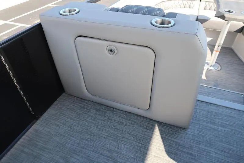 Slide: The Image of 2021 Bennington 24 RTFB boat interior with storage compartment and cup holders. - 11