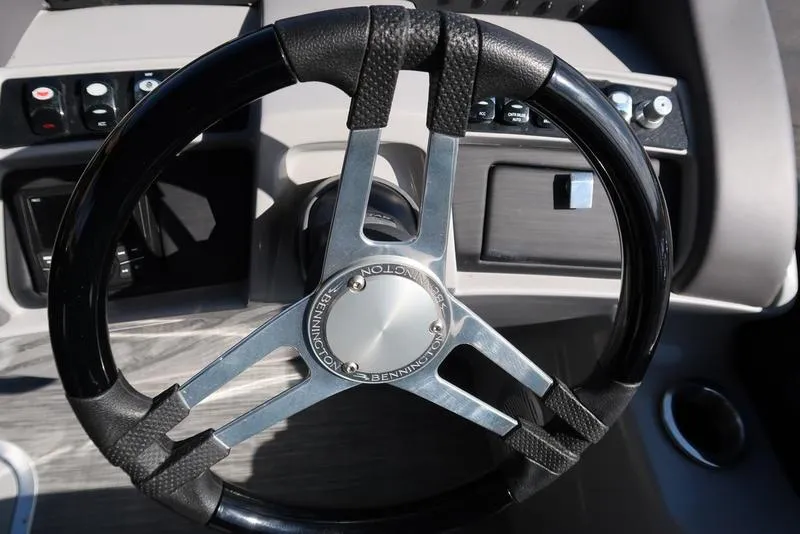 Slide: The Image of Steering wheel of a 2021 Bennington 24 RTFB boat, featuring sleek design and controls. - 19