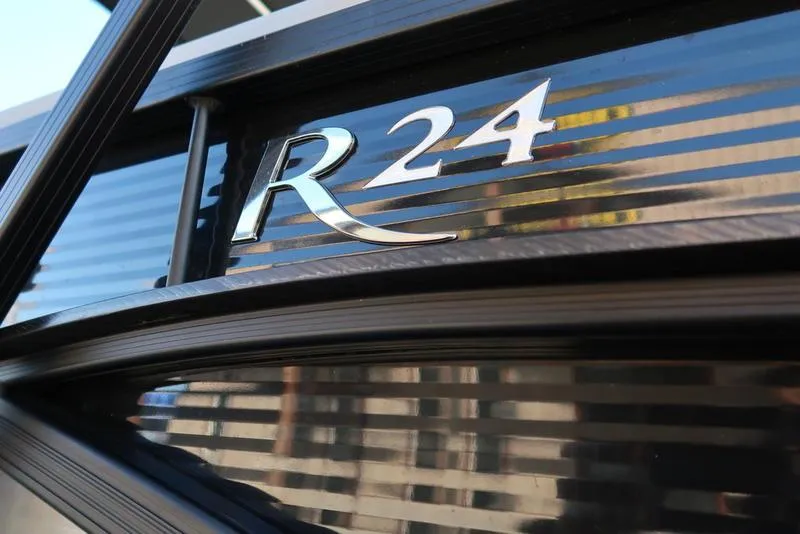 Slide: The Image of 2021 Bennington 24 RTFB boat model emblem on sleek black surface. - 35