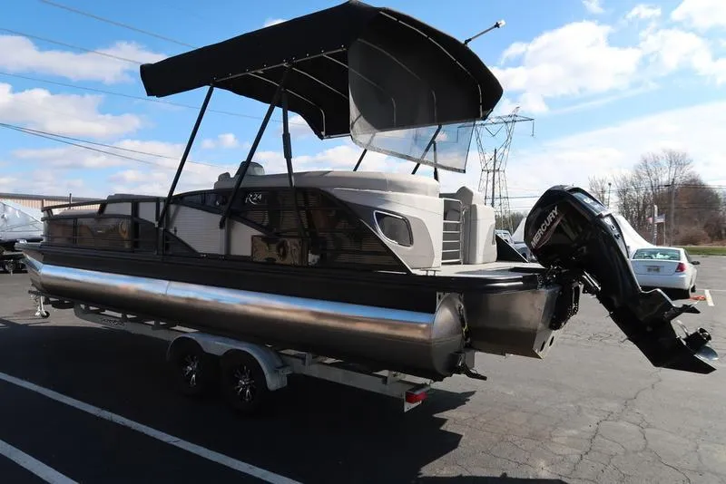 Slide: The Image of 2021 Bennington 24 RTFB pontoon boat with canopy and outboard motor on trailer. - 47