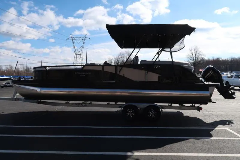 Slide: The Image of 2021 Bennington 24 RTFB pontoon boat on trailer, parked outdoors under blue sky. - 48