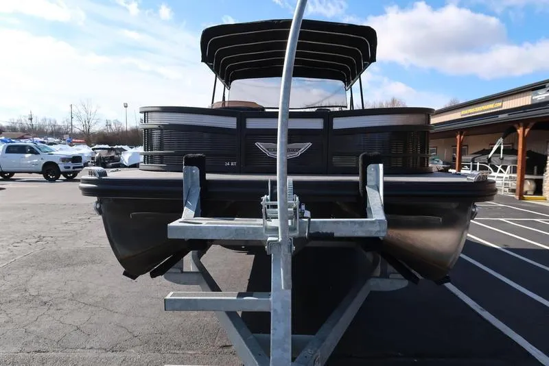 Slide: The Image of 2021 Bennington 24 RTFB pontoon boat on trailer, parked outdoors under blue sky. - 49