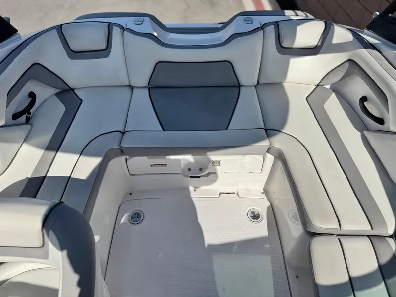 Slide: The Image of 2018 Yamaha Boats AR190 interior seating with white and gray upholstery. - 16