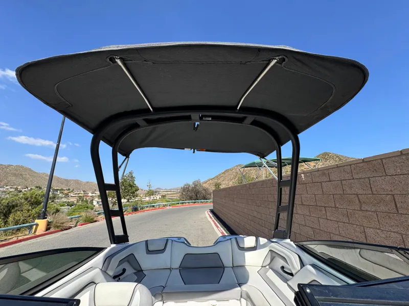 Slide: The Image of 2018 Yamaha AR190 boat with canopy, parked on a sunny day near a brick wall. - 9