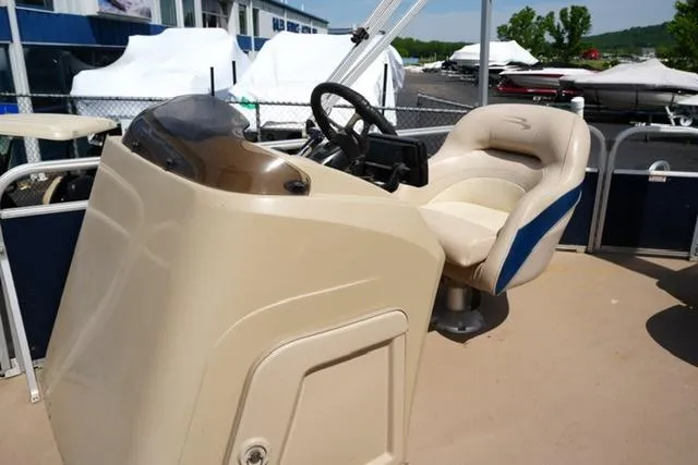 Slide: The Image of 2012 Bennington 24 SLX boat helm with beige seating and steering wheel. - 8