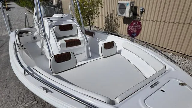 Slide: The Image of 2025 ALK2 22CRX boat with white seating and brown accents, docked outdoors. - 11