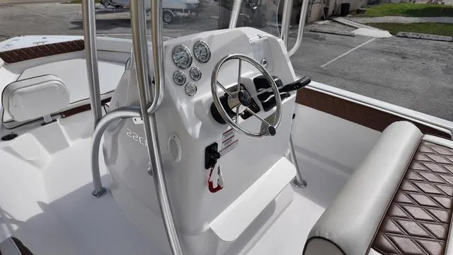 Slide: The Image of ALK2 22CRX 2025 boat console with steering wheel and gauges, featuring brown cushioned seating. - 20